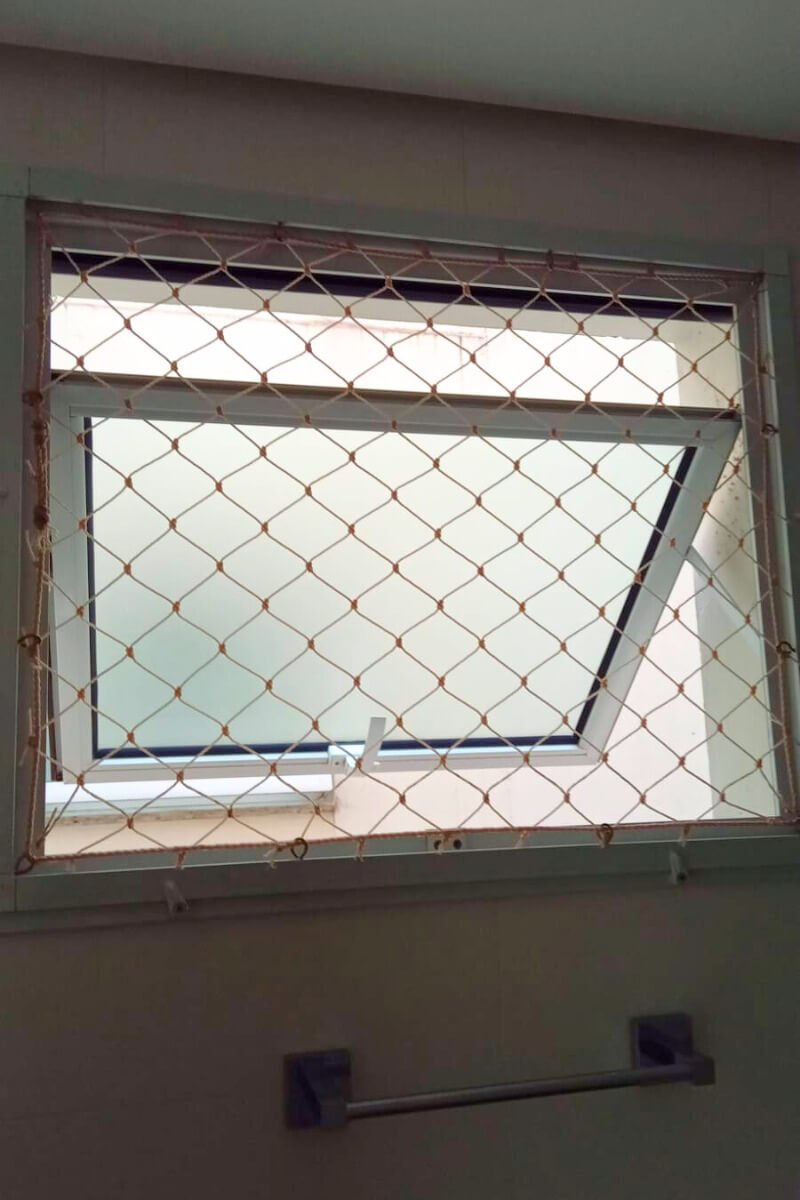 Detalhe de instalação de rede de segurança em janela basculante ou maxim-ar com vidro fosco.